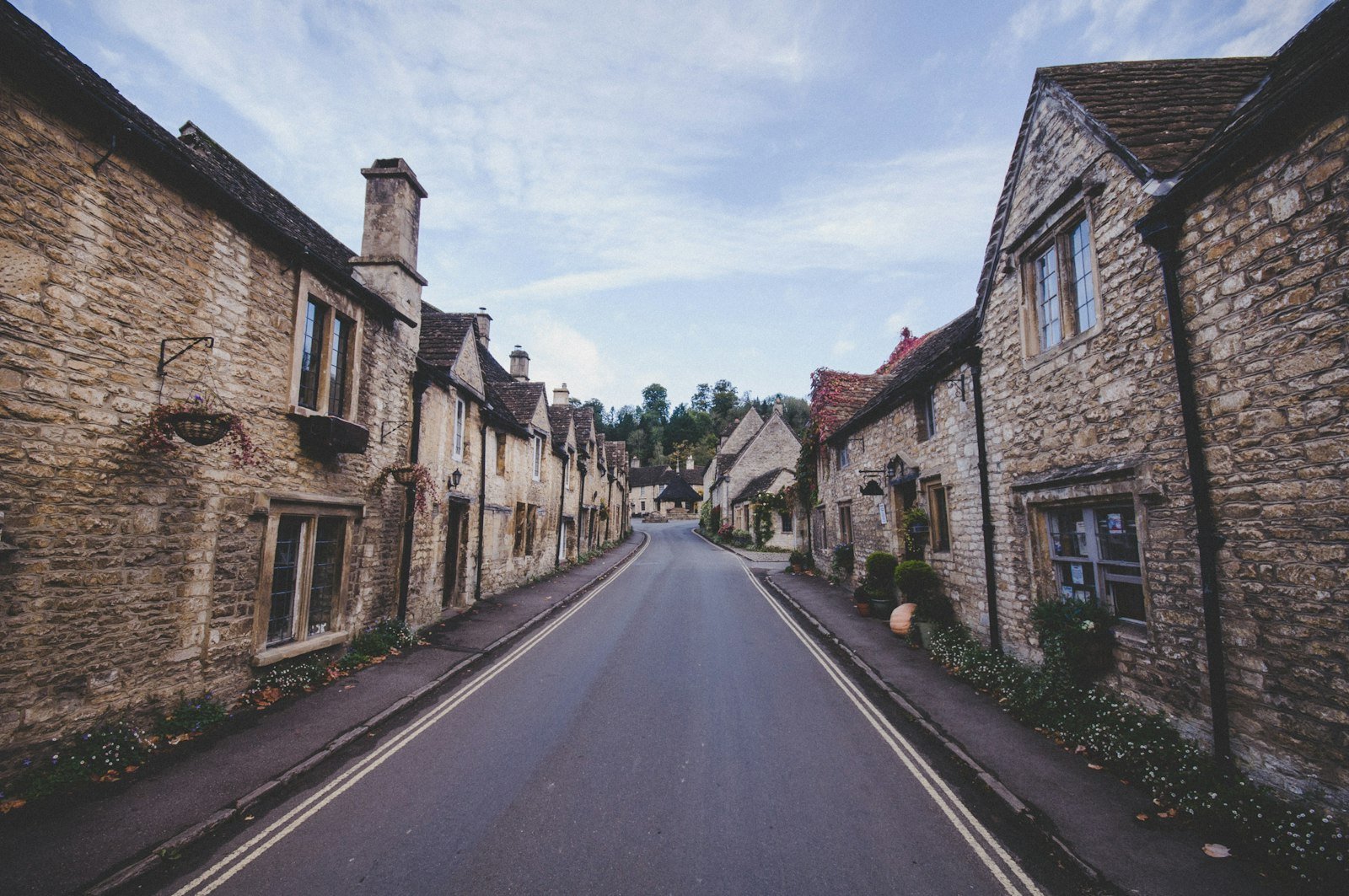 Charming street view in Corsham showcasing traditional stone cottages and a clean road, emphasizing the area's appeal for Chippenham Cleaning services.
