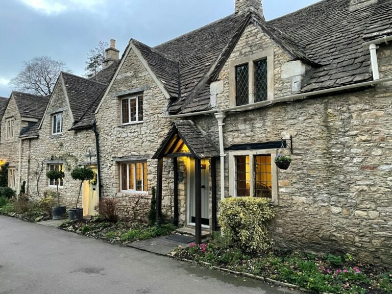 Charming stone cottages in Devizes with warm lighting, showcasing local architecture and landscaping.