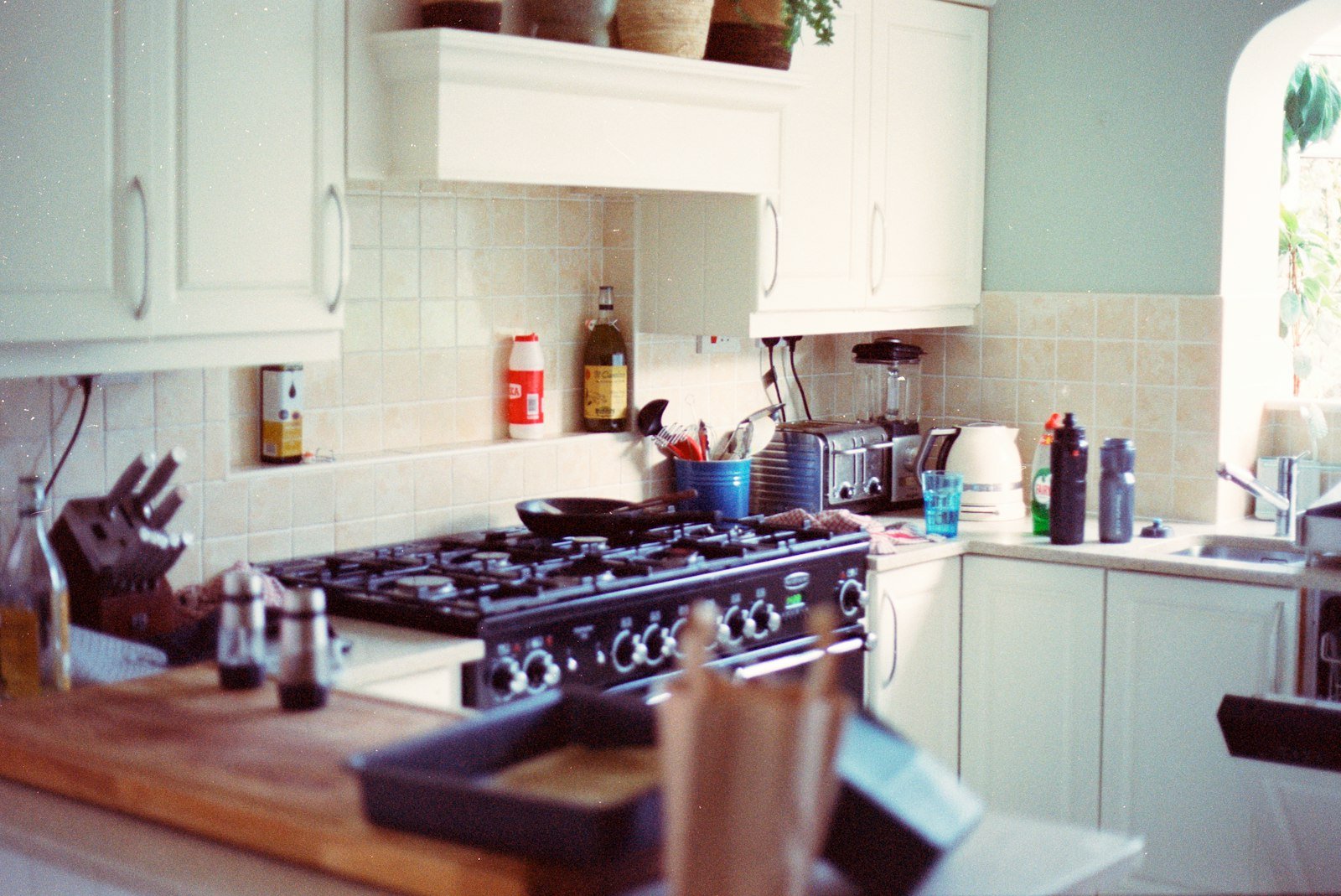 Modern kitchen interior with clean countertops, gas stove, and various kitchen appliances, highlighting the importance of domestic cleaning services for homeowners.