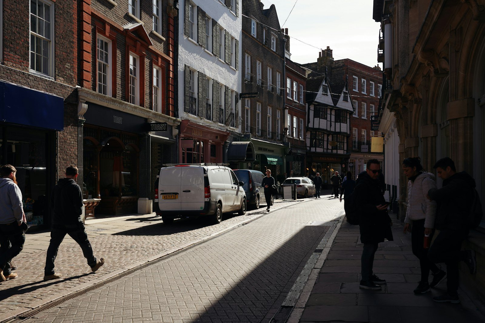 Street scene in Melksham with pedestrians, shops, and parked vehicles, reflecting the local community and services offered by Chippenham Cleaning.