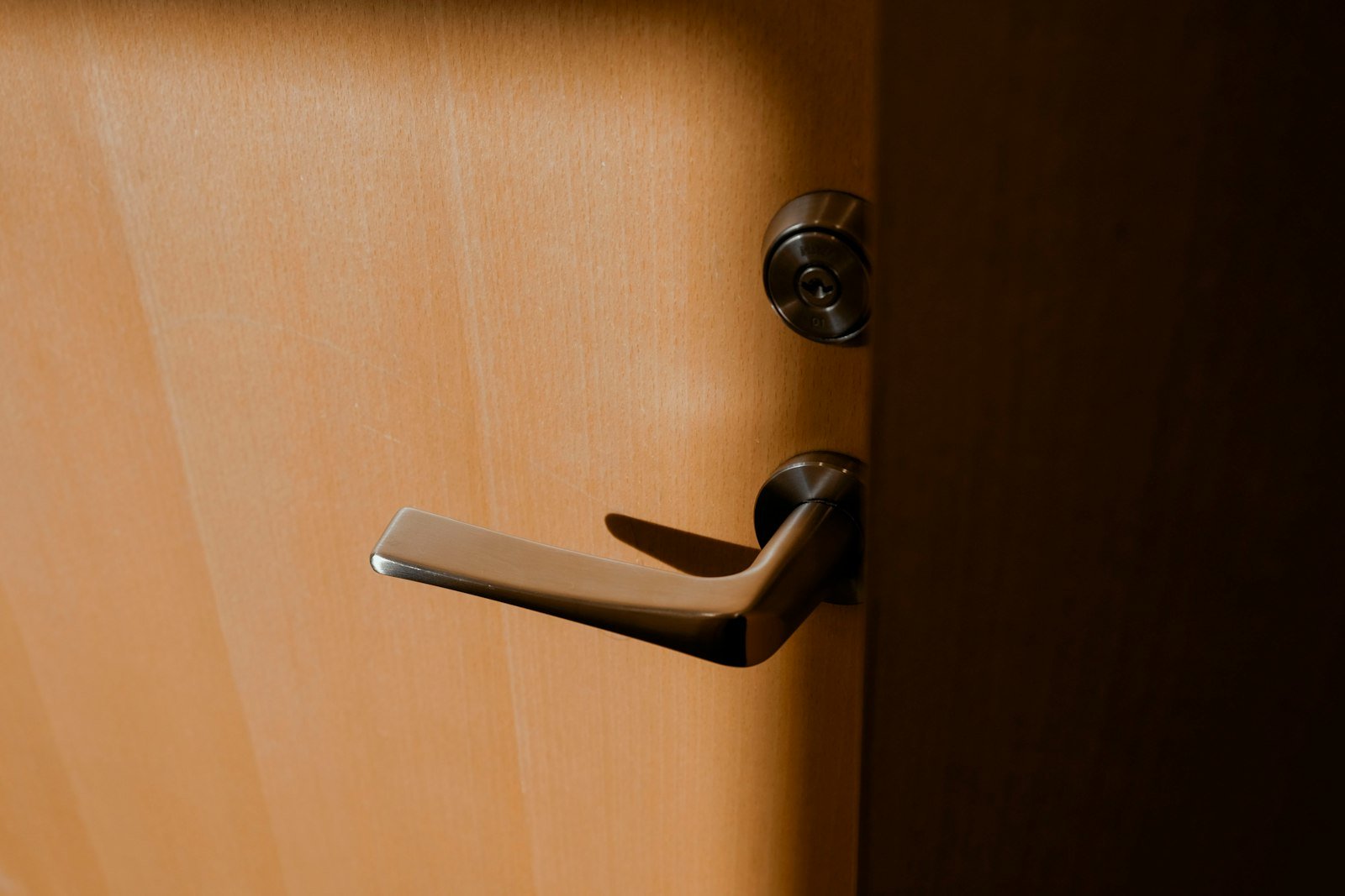 Door handle on a wooden office door, symbolizing access to clean and professional office environments in Melksham.