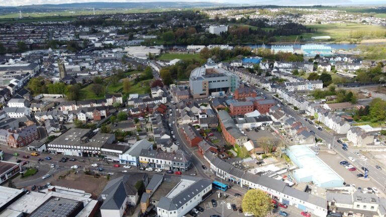 Aerial view of Royal Wootton Bassett showcasing residential and commercial areas, highlighting local amenities and surrounding landscape.